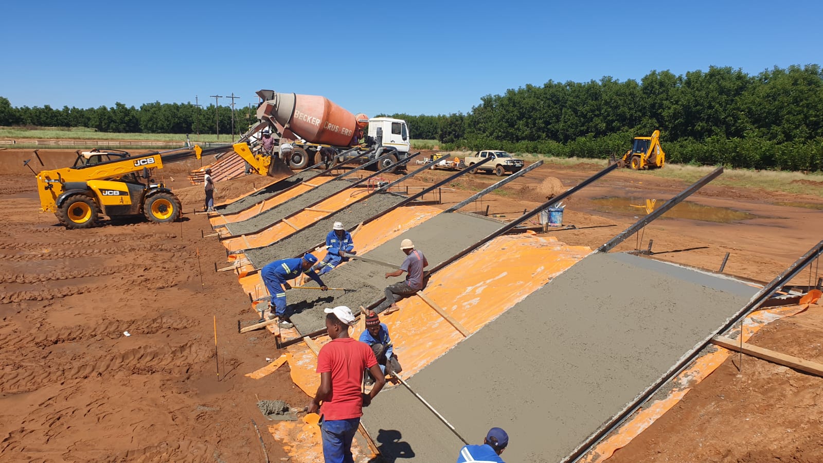 Aurex Innovations crew placing and screeding a reinforced-concrete slab on site